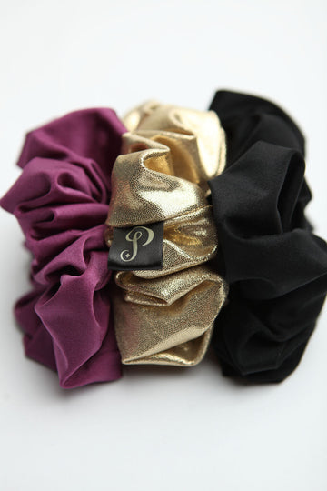 Chouchous mauve, noir et or délicatement posés les uns à côté des autres, légèrement floutés pour un effet artistique, représentant une palette de couleurs tendance.